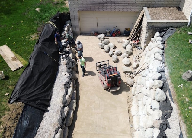 Kyle Wheeler operating excavation equipment on a Washtenaw County hardscape project